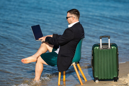 Freelancer typing on laptop by sea. Beach freelancer builds online business. Freelancer lifestyle shows travel freedom. Coastal office supports freelancer success.