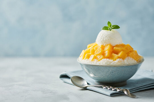 AI generated korean shaved ice bingsu with mango cubes and ice cream in bright summer tone minimal clean background refreshing sweet dessert concept