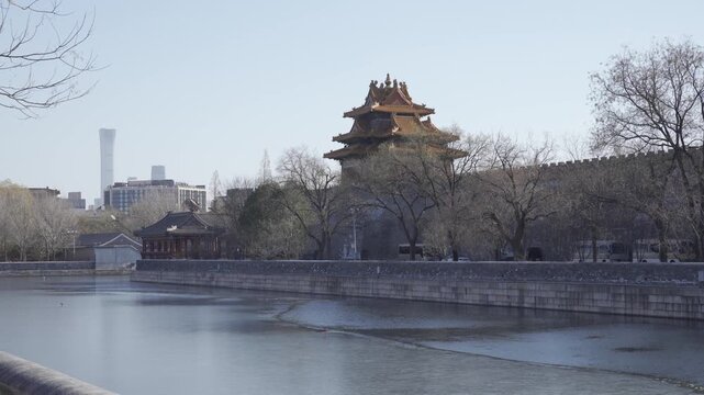 view to ancient wall of forbidden city with chinese archiecture wooden building on the wall in winter sunny daytime and frozen canel, chinese famouse landmark building 