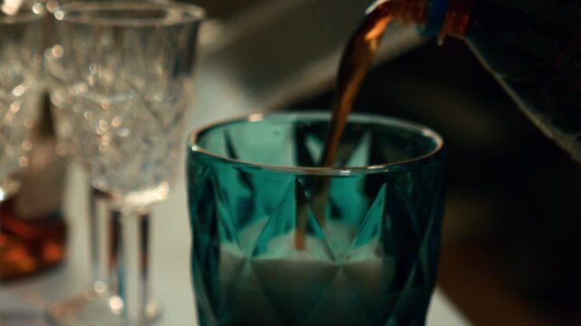 Сola is pouring into a blue glass