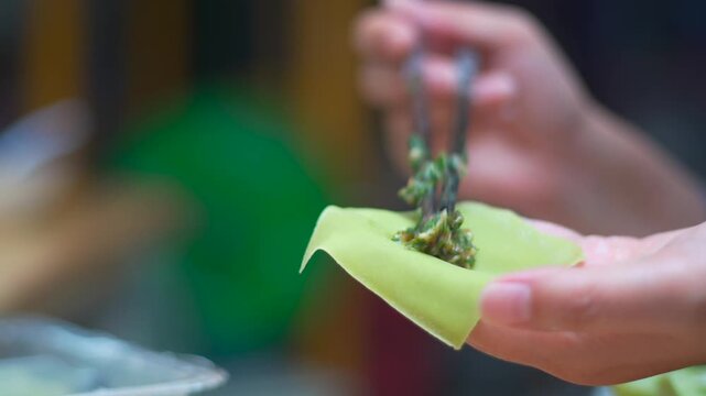 Hands Making Green Dumplings in Kitchen