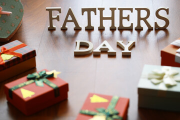 Naklejka premium Fathers Day Celebration with Gifts and Decorative Letters on Wooden Background