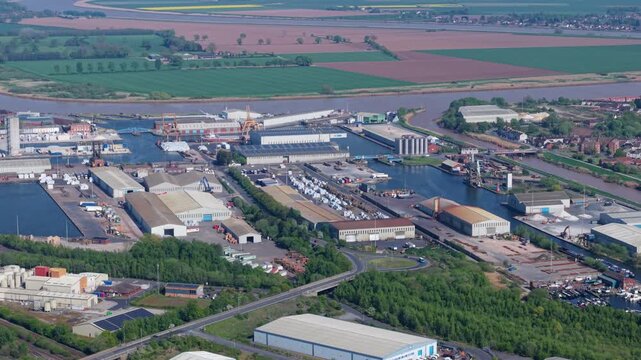 Aerial view of Goole Docks featuring industrial warehouses, shipping basins, and the River Ouse surrounded by green fields in Goole, England, United Kingdom.