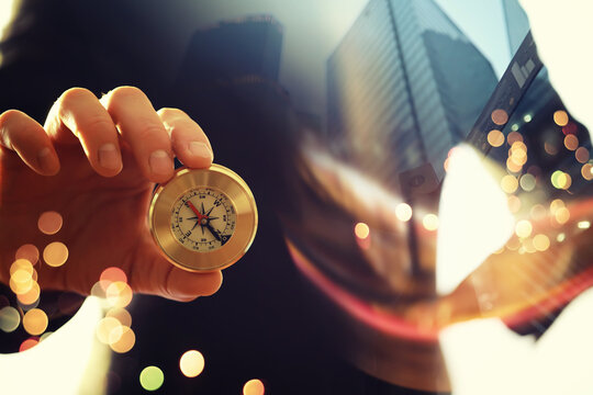 Double exposure businessman with vintage compass in a hand and skyscraper.  concept to make decision or choose direction