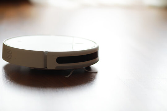 Smart Robot Vacuum Cleaner on Wooden Floor for Efficient Home Cleaning