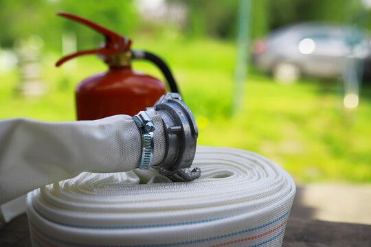 hand presses the trigger fire extinguisher available in fire emergencies conflagration damage background. Safety