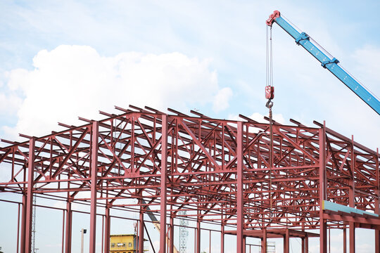 Industrial Construction Site with Steel Frame Building and Crane in Progress