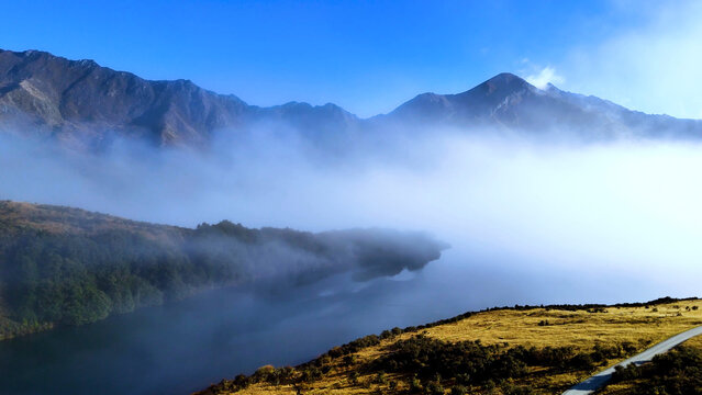 Aerial View of Mist Rolling Over Moke Lake and Mountains in Queenstown