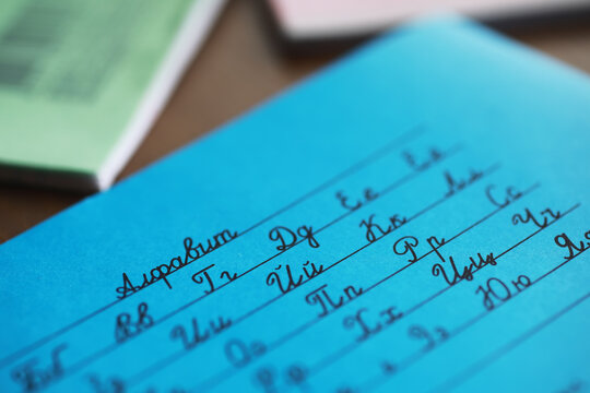 Close-Up of Handwritten Cyrillic Alphabet on Blue Paper Sheet in Classroom