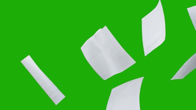 A group of white sheets of paper falling and tumbling in the air, isolated on a chroma key green background. This asset is designed for easy compositing in office, school, or business-related video pr