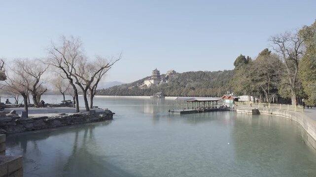 natural landscape view at of chinese manmade kunming lake with background of mountain hill and chinese architecture pagoda of Beijing Summer palace in winter daytime,lake and garden in chinese style