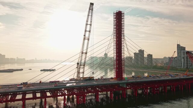 Aerial view of bridge sections being dismantled with a large crane over a river