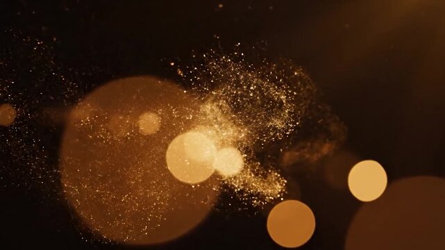 Soft glowing bokeh lights and sparkling particles on a dark background