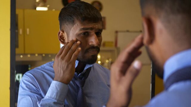 Young Indian male in office college attire adjusts tie while staring into a mirror, unhappy with acne-ridden tanned skin; an intimate bedroom moment reflecting self-image concerns and insecurity