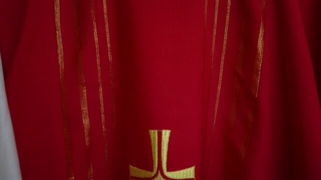 Red priest vestment featuring detailed gold cross embroidery for religious ceremonies