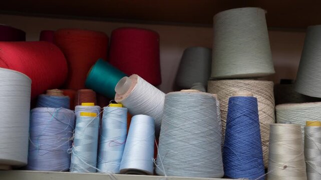 Colorful sewing threads and vibrant textile yarns used for knitting various handmade artisanal fashion products