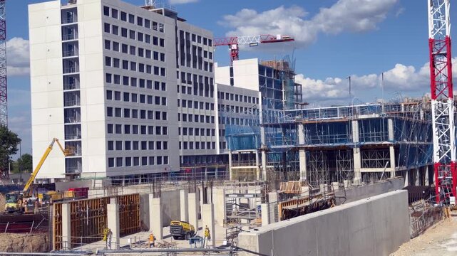 Madrid, Spain - May 4, 2026: Large residential construction site with Dragados tower cranes, scaffolding and modern buildings under development in Madrid, Spain.