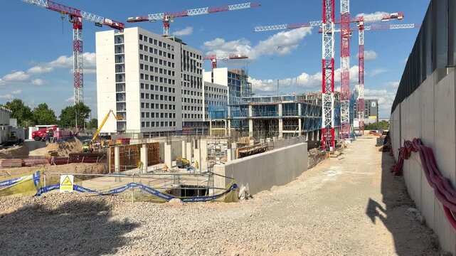Madrid, Spain - May 4, 2026: Large construction site operated by Dragados with multiple tower cranes, reinforced concrete structures and residential buildings under development in Valdebebas, Madrid.