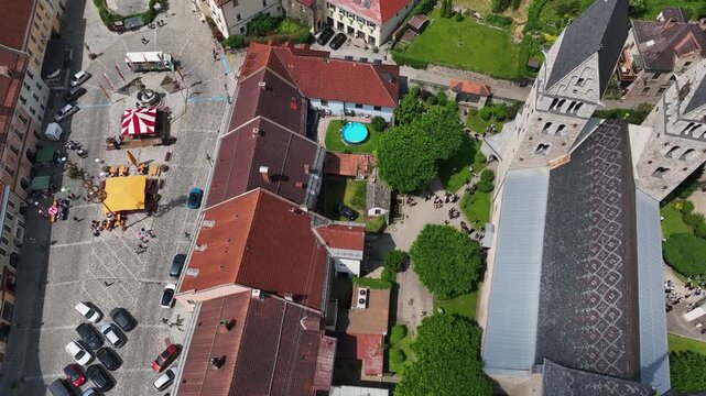 Summer drone footage showing medieval Friesach, old fortified walls, rooftops, towers, hills, serene atmosphere, warm daylight, gentle cinematic motion