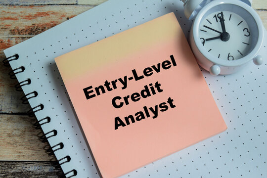 Concept of entry-level credit analyst write on sticky notes isolated on Wooden Table.