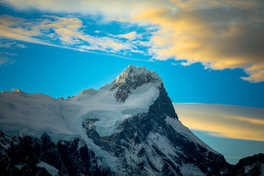 Snow covered mountain peak with glowing cloud cap, Patagonia Chile