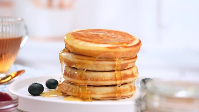 Pancakes stack with dripping honey syrup and blueberries