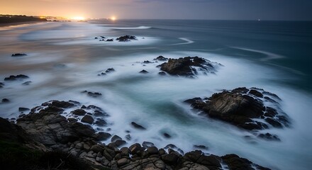 Fototapeta premium serene ocean waves crashing on rocky shoreline at sunset
