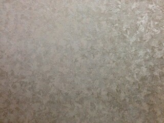Fototapeta premium A metallic surface with irregular patterns and shiny reflective textures.