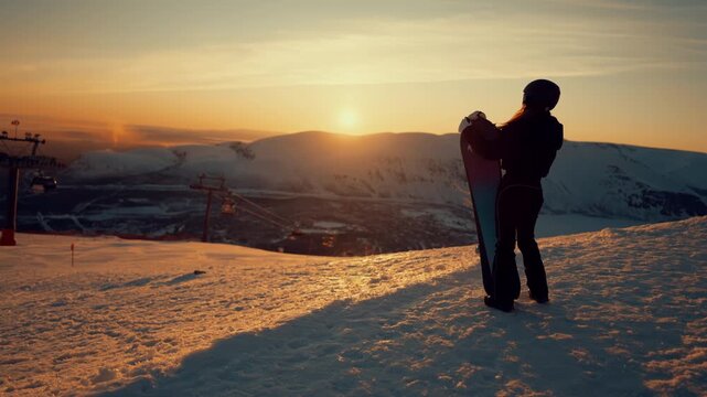 Beautiful panoramic view from top of mount, female snowboarder admiring sunset. Enjoy life and conquer summit, move to dream and explore new ability, fascinating scenery in ski resort, alpine skiing