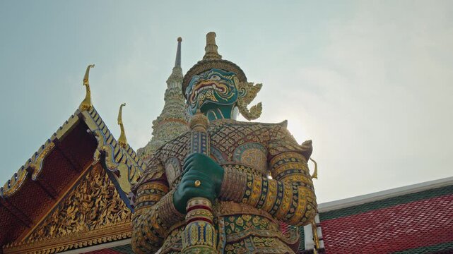 Giant guardian demon statue at Temple of the Emerald Buddha in Bangkok, ornate Thai architecture and mythology landmark in Thailand