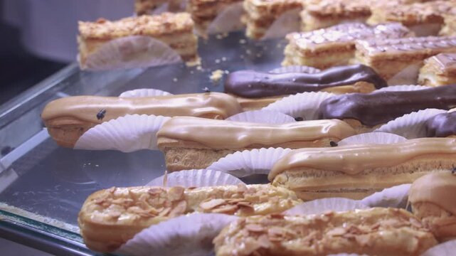 Moroccan pastry shop displaying delicious eclairs and traditional sweets attracting many bees, a sign of freshness and quality