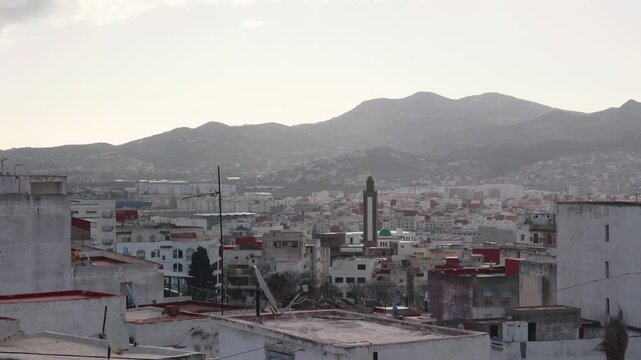 Scenic aerial view of Tetouan, Morocco, with white buildings, a mosque and the Rif Mountains in the background