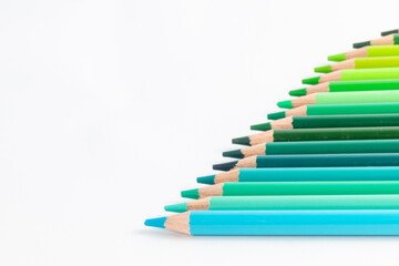 Obraz premium Green and Blue Gradient Colored Pencils in Diagonal Row on White Background