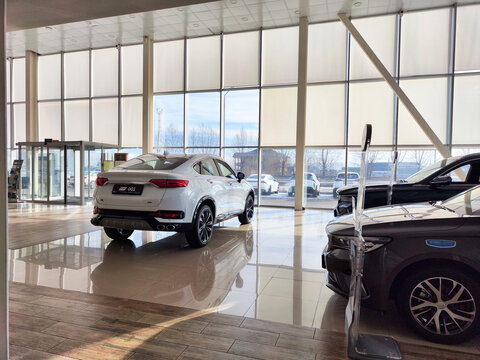 Ulan-Ude, Russia - November 04, 2024: Modern Geely dealership showroom features new cars and spacious design for customer experience