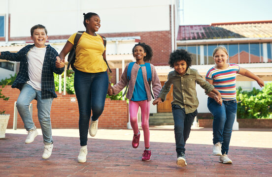Happy, children and holding hands at school with walk, bonding together and education for growth. Students, friends and skipping at recess with diversity, wellness and learning for skill development.
