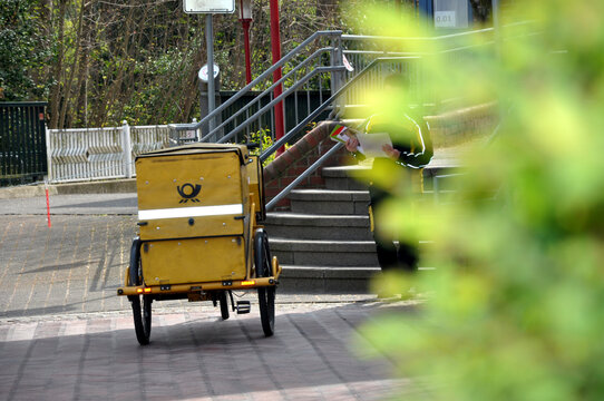 Deutsche Post, Kurierfahrer liefert Post mit dem Fahrrad in der Stadt aus