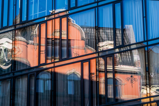 Abstract architecture composition showing a facade of modern glass reflection over historic forms with windows pattern and vivid color contrast