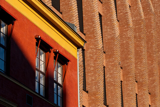 Oslo architecture closeup of a historic brick facade with colorful surfaces and windows where texture and shadow bring out crafted detail
