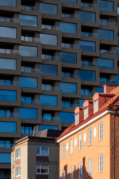City architecture study where a modern highrise building facade rises over historic residential windows in Stockholm highlighting contrast between eras