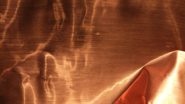 Abstract copper metallic background with warm tones. Sunlight, copper, and shadow. Design backgrounds. Minimal. Selective focus.