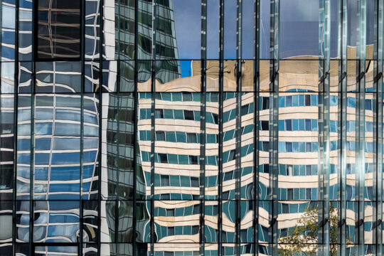 Abstract corporate reflections with subtle distortion on modern glass facade turn the building architecture pattern into fluid visual rhythm
