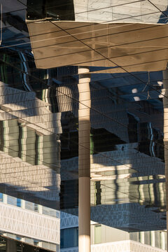 Reflection and symmetry align within a modern grid on a glass facade creating abstract corporate architecture pattern for clean editorial design