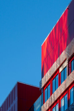 Bold red building facade cuts into clear sky with copy space minimal urban exterior architecture modern geometry for creative advertising layout