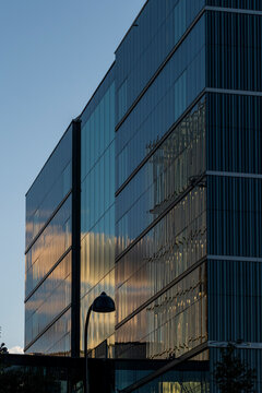 Streetlamp silhouette near glass building facade against bright sky with copy space minimal urban exterior architecture modern reflections background