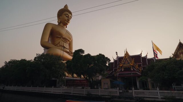 Large golden Buddha statue at Wat Paknam Phasi Charoen in Bangkok Thailand during daylight. Iconic Buddhist landmark with traditional temple architecture and spiritual atmosphere.