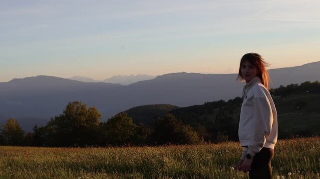 Woman watching sunset over alpine landscape in Italy with scenic mountain view