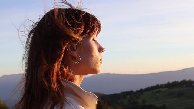 Woman enjoying sunset in Italian Alps with golden evening light