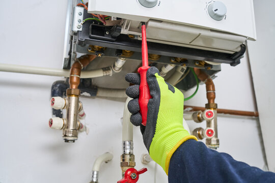 Technician repairing combi Gas Boiler  at home