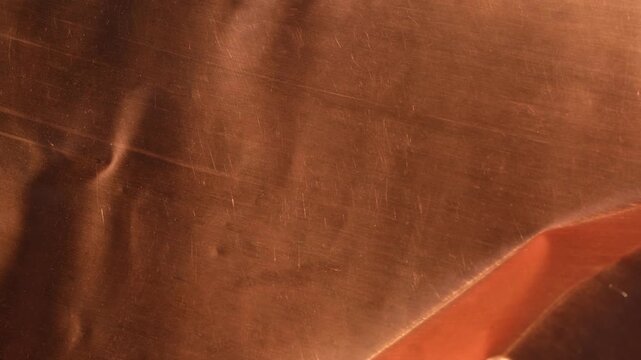 Thin copper sheet, or thin-gauge sheet metal. Warm red and bronze tones. Random movement.