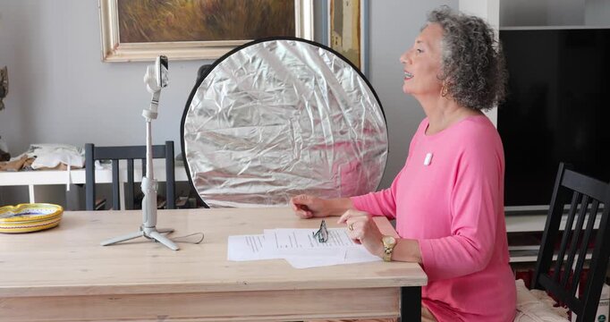 Senior Woman Recording Video Blog at Home with Smartphone and Gimbal, Content Creator Concept, Active Aging and Digital Inclusion